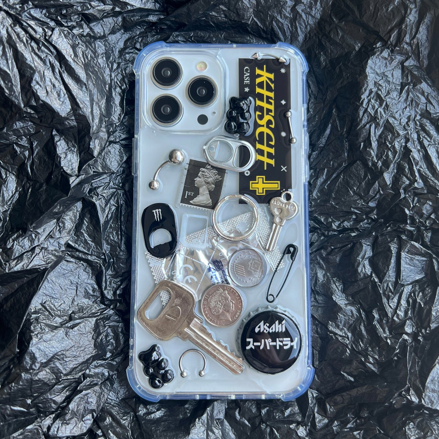Artisan black collage phone case with dark aesthetic punk trinkets shot on a moody black background