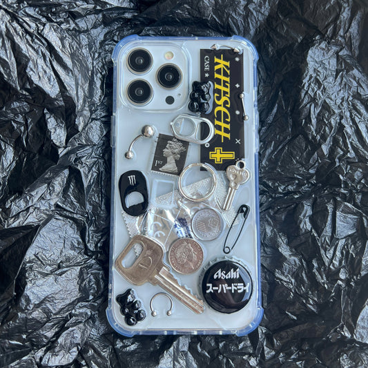 Artisan black collage phone case with dark aesthetic punk trinkets shot on a moody black background