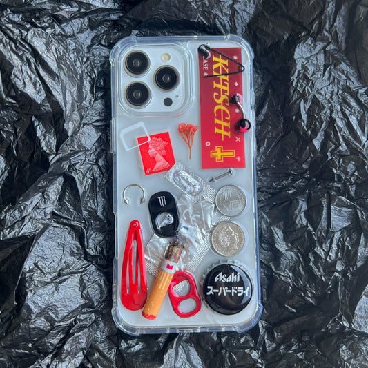 Handmade red collage art phone case with vibrant Y2K aesthetic charms shot on a dramatic black background.